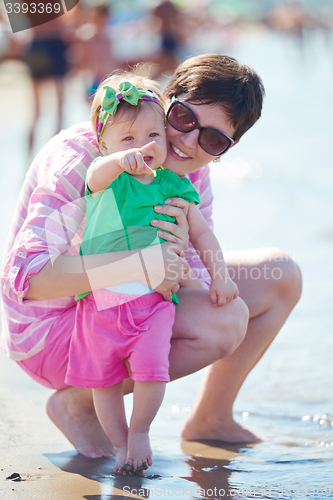 Image of mom and baby on beach  have fun