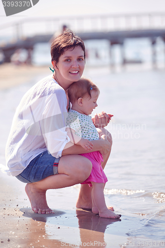 Image of mom and baby on beach  have fun