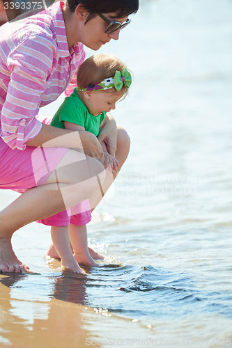 Image of mom and baby on beach  have fun