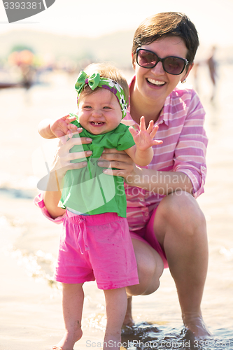 Image of mom and baby on beach  have fun