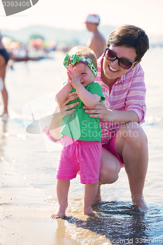 Image of mom and baby on beach  have fun