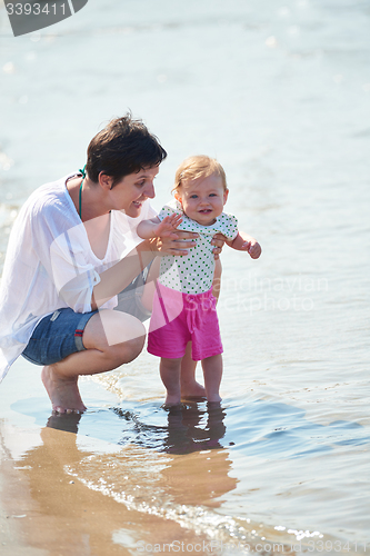 Image of mom and baby on beach  have fun