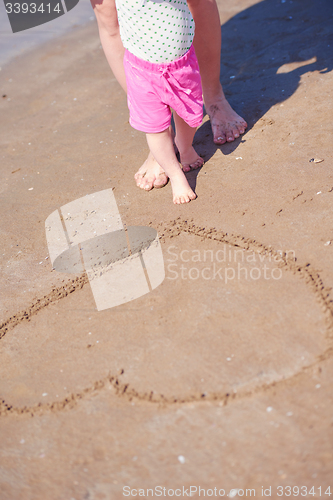 Image of mom and baby on beach  have fun