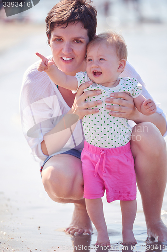 Image of mom and baby on beach  have fun