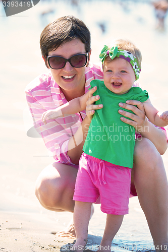 Image of mom and baby on beach  have fun