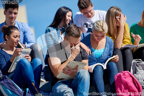 Image of students outside sitting on steps