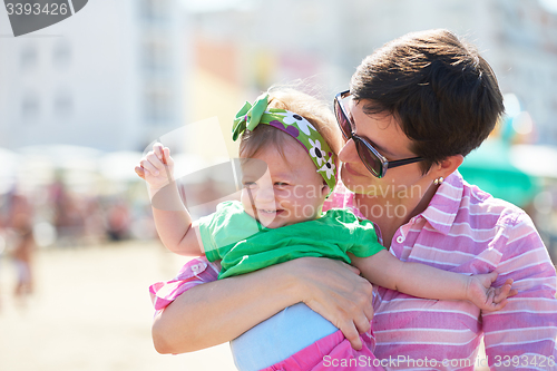 Image of mom and baby on beach  have fun