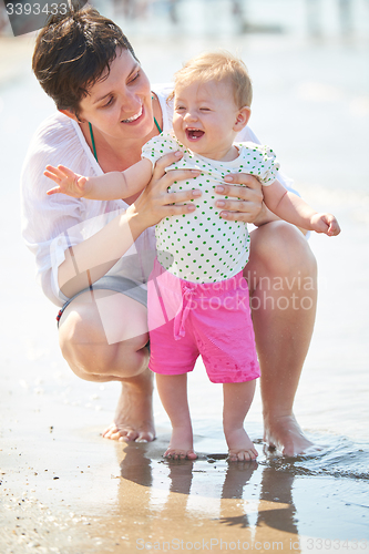 Image of mom and baby on beach  have fun