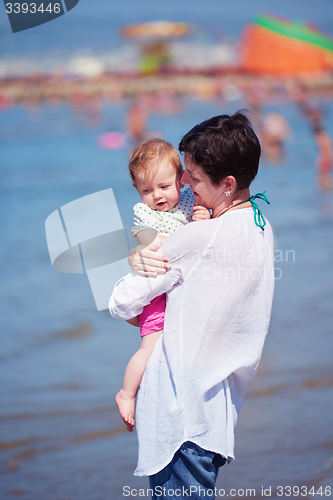 Image of mother walking on beach and push baby carriage