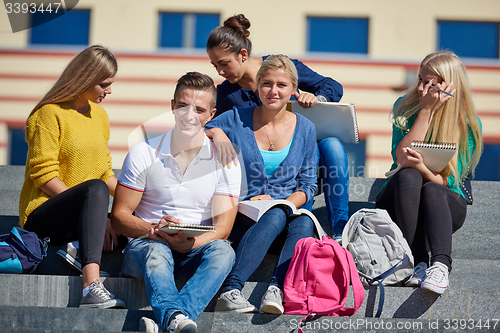 Image of students outside sitting on steps