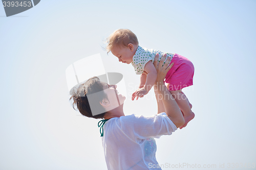 Image of mom and baby on beach  have fun