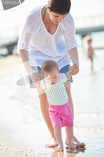 Image of mom and baby on beach  have fun