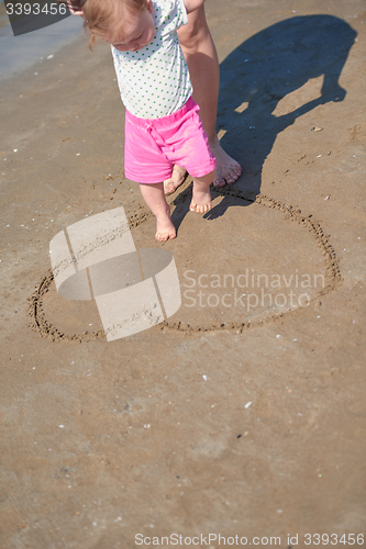 Image of mom and baby on beach  have fun