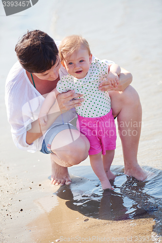 Image of mom and baby on beach  have fun