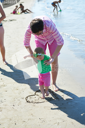 Image of mom and baby on beach  have fun