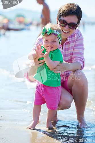 Image of mom and baby on beach  have fun