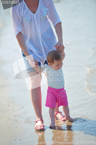 Image of mom and baby on beach  have fun