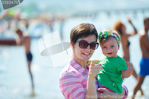 Image of mom and baby on beach  have fun