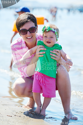Image of mom and baby on beach  have fun