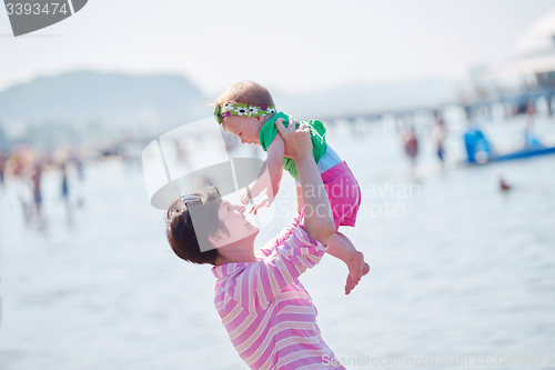 Image of mom and baby on beach  have fun