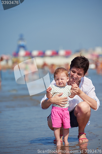 Image of mom and baby on beach  have fun