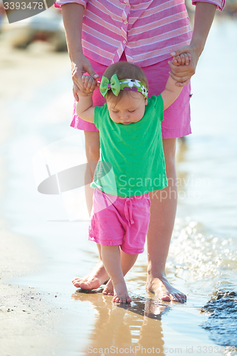 Image of mom and baby on beach  have fun