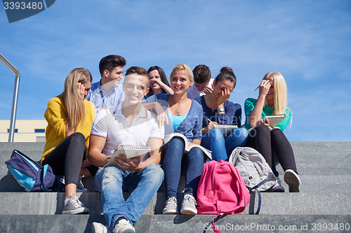 Image of students outside sitting on steps