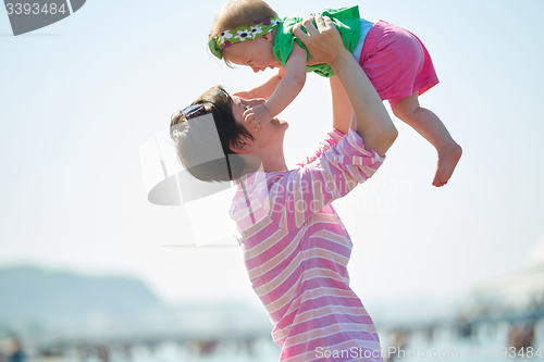 Image of mom and baby on beach  have fun
