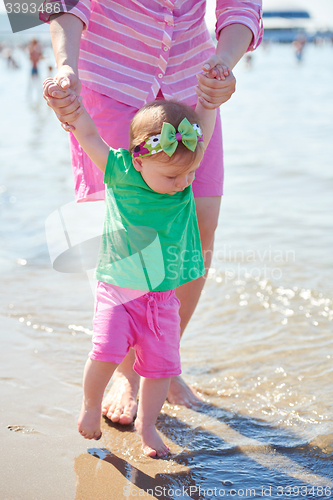 Image of mom and baby on beach  have fun