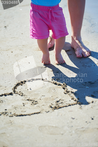 Image of mom and baby on beach  have fun