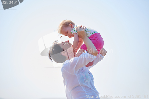 Image of mom and baby on beach  have fun