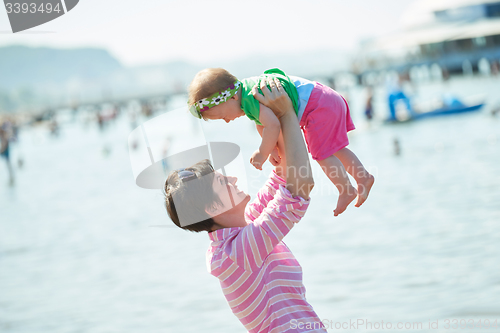 Image of mom and baby on beach  have fun