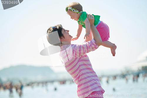 Image of mom and baby on beach  have fun