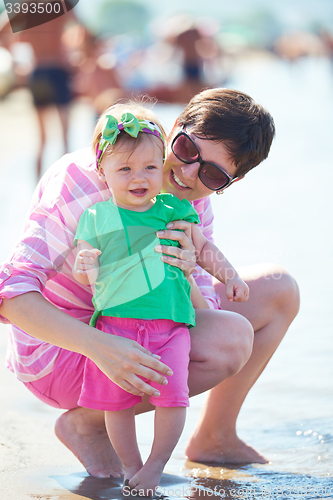 Image of mom and baby on beach  have fun