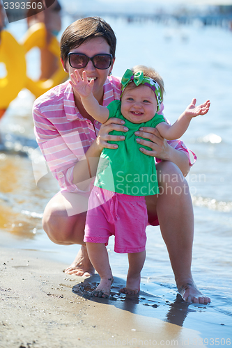 Image of mom and baby on beach  have fun