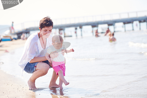 Image of mom and baby on beach  have fun