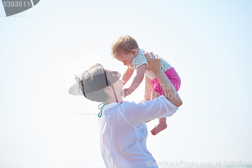 Image of mom and baby on beach  have fun