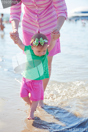 Image of mom and baby on beach  have fun