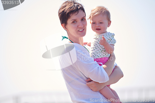 Image of mom and baby on beach  have fun