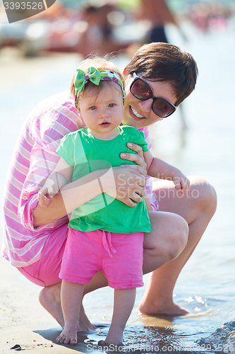 Image of mom and baby on beach  have fun