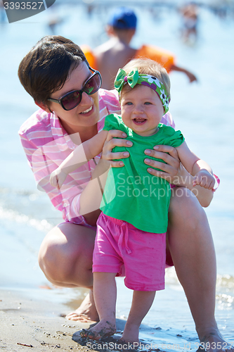 Image of mom and baby on beach  have fun