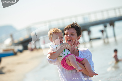 Image of mom and baby on beach  have fun