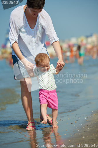 Image of mom and baby on beach  have fun