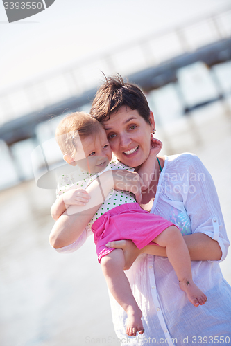 Image of mom and baby on beach  have fun