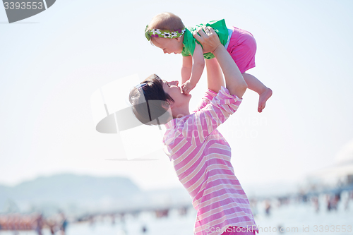 Image of mom and baby on beach  have fun