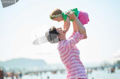 Image of mom and baby on beach  have fun