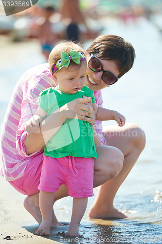 Image of mom and baby on beach  have fun