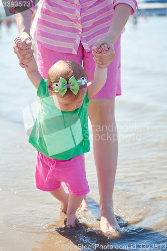 Image of mom and baby on beach  have fun