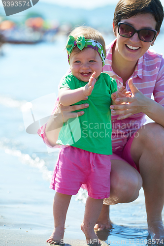 Image of mom and baby on beach  have fun