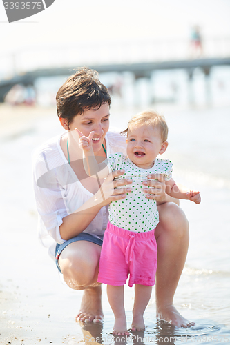 Image of mom and baby on beach  have fun